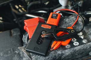 The Weego 22s portable jump starter sitting on top of a car engine.