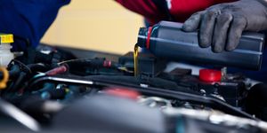 car mechanic changing engine oil